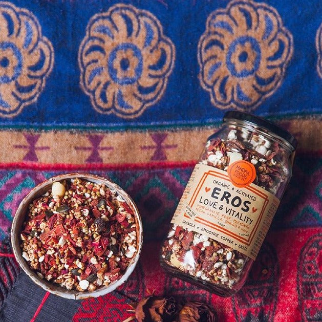 Bowl of organic & activated Eros Love & Vitality granola in bowl with jar lying next to it on a blanket