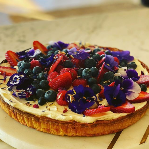short pastry tart with custard, blueberries, strawberries and 24carat gold edible flower garnish 