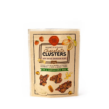 Organic & activated chocolate clusters with native davidson plum - gluten friendly in a Compostable resealable bag with pictures of fruit and nuts and images of the clusters.   Ingredients include cacao, pecans, nutmeg, coconut, raspberry, dates, walnuts and more
