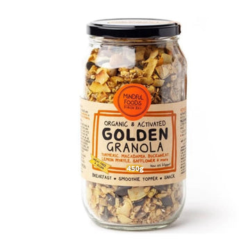 Glass jar clear to show golden granola contents with label describing organic & activated golden granola. Some ingredients displayed on label are turmeric, macadamia, buckwheat, lemon myrtle, safflower and more. It is made by Mindful Foods and is wheat free & vegan