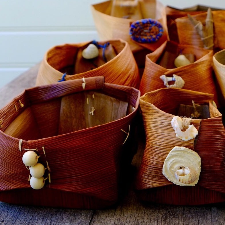 Handwoven baskets made from natural fibre Bangalow Palm with no handles, decorated with shells and natural beads.